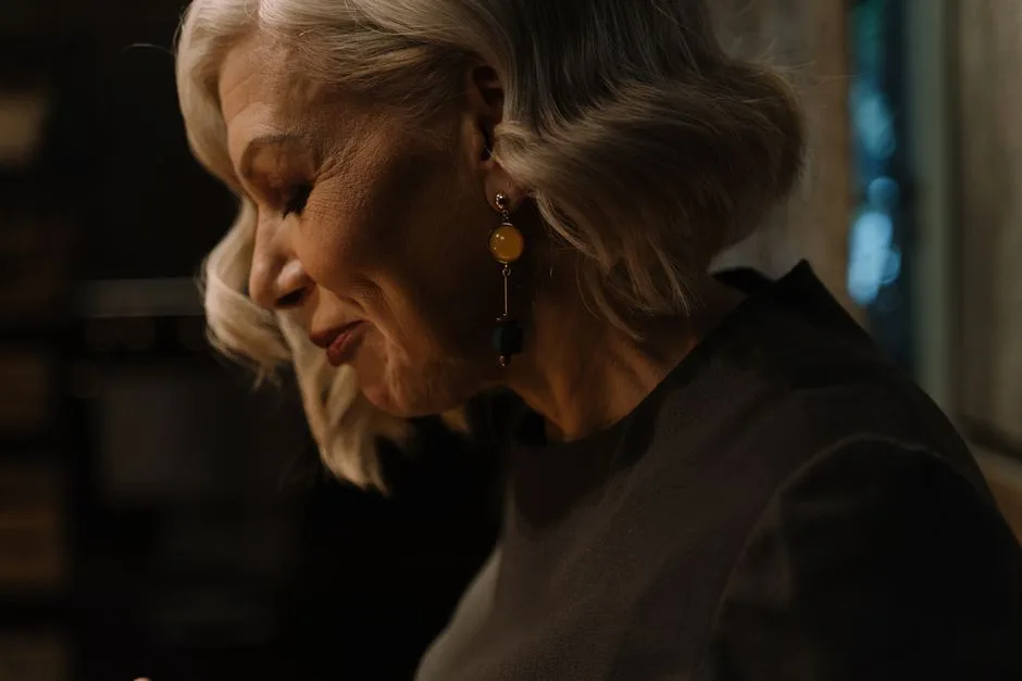 Side view portrait of a senior woman with gray hair, smiling gracefully.
