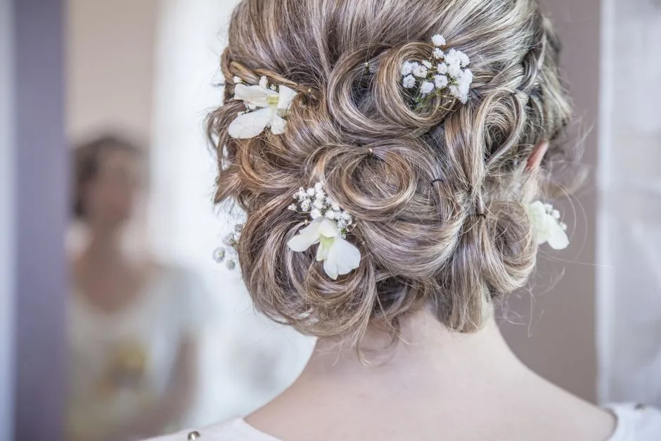 Elegancka fryzura ślubna z delikatnymi białymi kwiatami